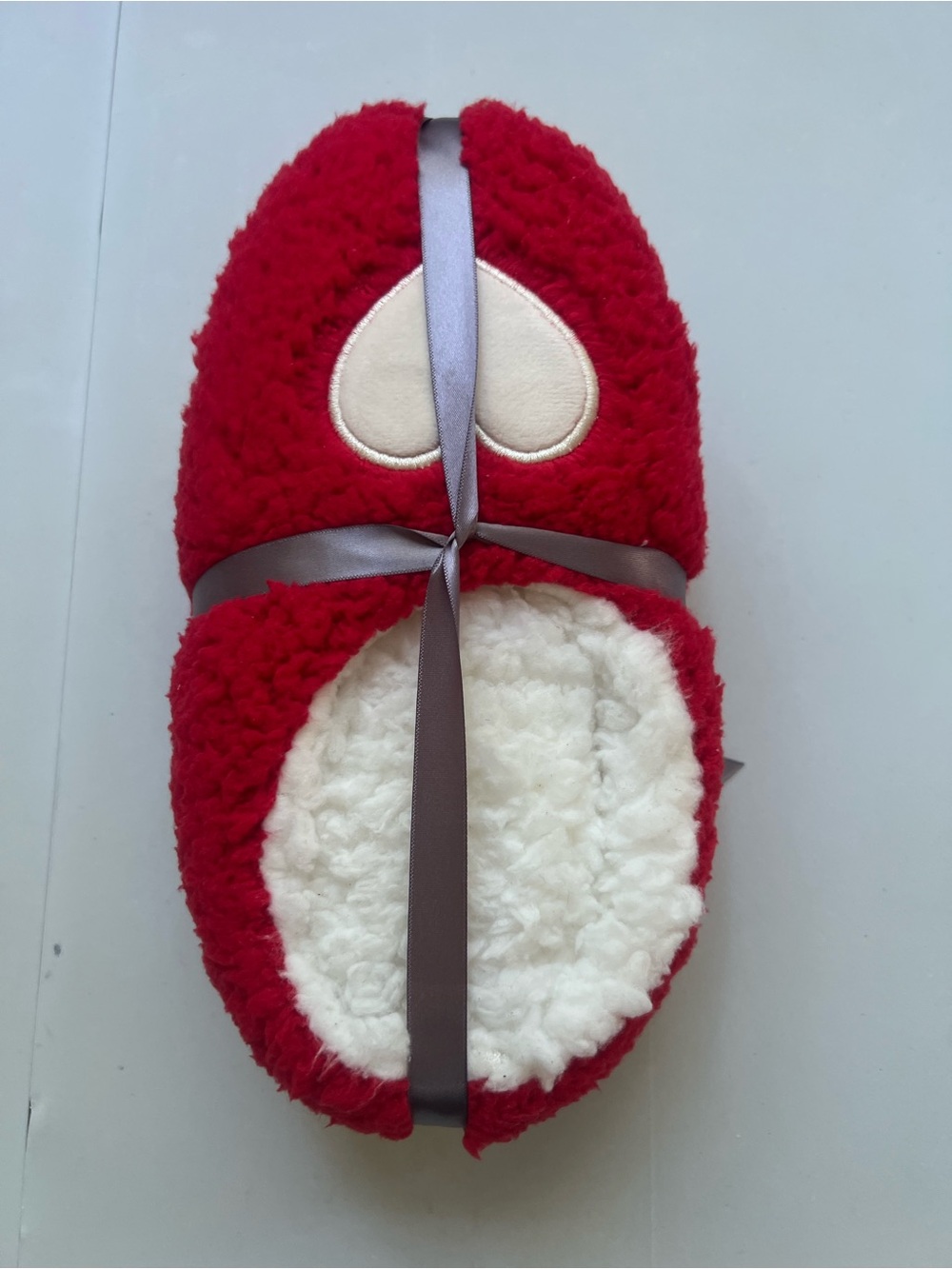 Red & white fuzzy slippers with white heart-shaped patch